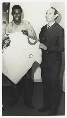 Entrega da camisa da seleção brasileira usada por Pelé (à esquerda) para leilão em Londres