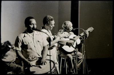 Nelson Cavaquinho ao microfone com o violão