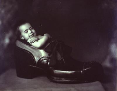 Retrato de criança dentro de enorme pé de sapato.