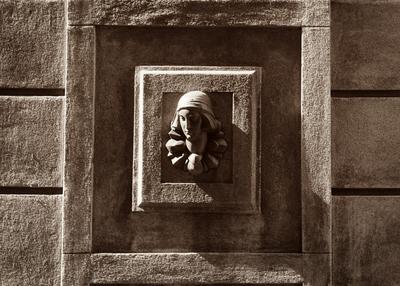 Cabeça de mulher, ao centro de detalhe, em fachada de edificação