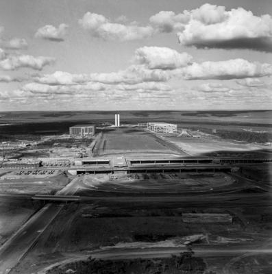 Vistas aéreas, à direita, a Catedral de Brasília e, em primeiro plano, a Estação Rodoviária do Plano Piloto. Ao fundo Praça dos Três Poderes, Esplanada dos Ministérios.