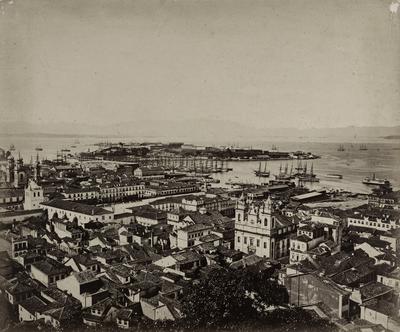 Praça D. Pedro II (atual Praça XV de Novembro) e arredores vistos do Morro do Castelo; ao centro, a igreja de São José e o passadiço ligando o Paço Imperial ao Convento do Carmo