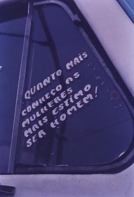 Janela de caminhão com a frase: "Quanto mais conheço as mulheres mais estimo ser homem"