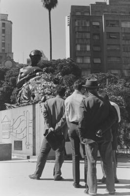 Homens olham o Monumento à Mãe Preta