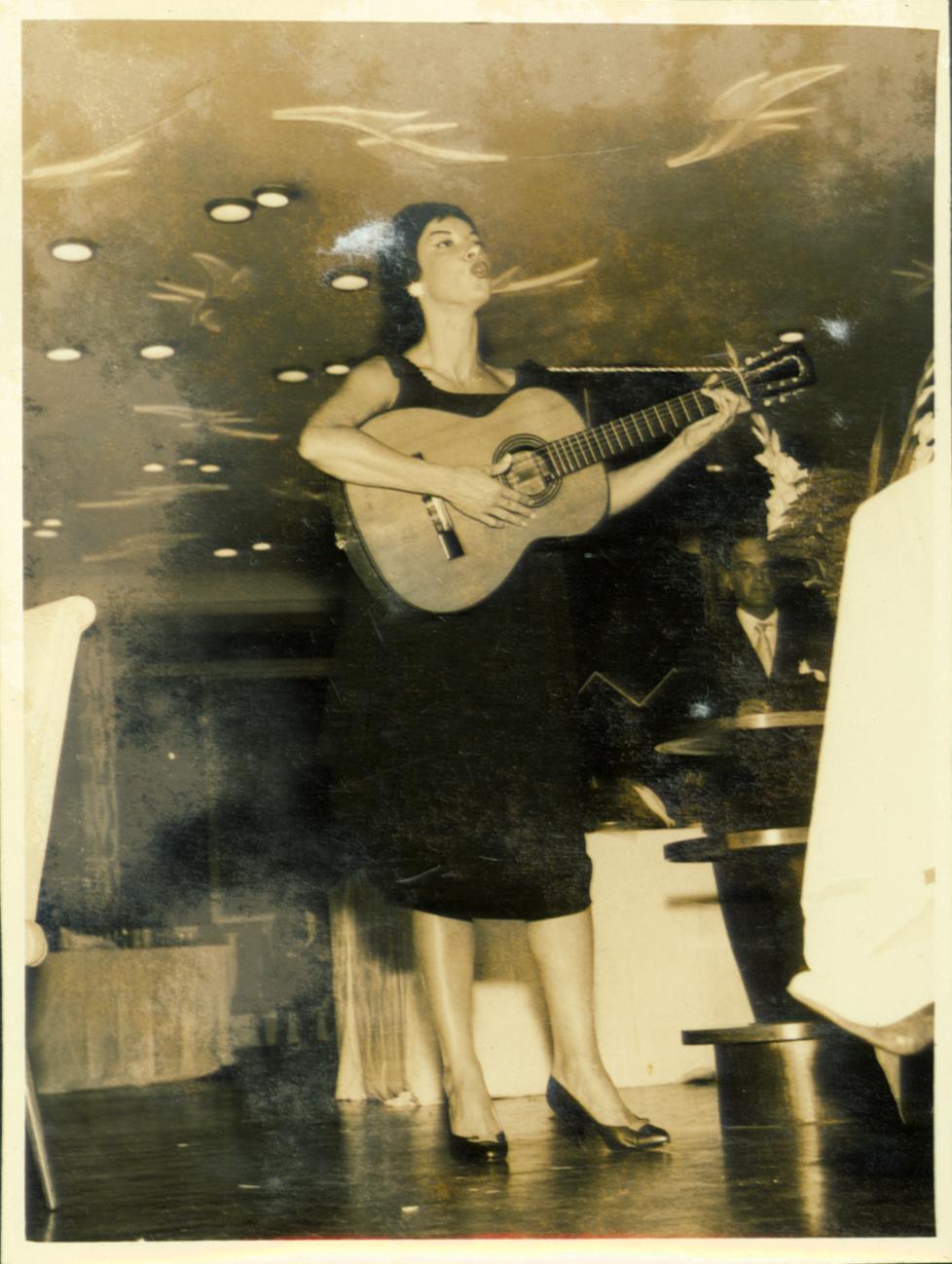 Inezita Barroso ao microfone com o violão