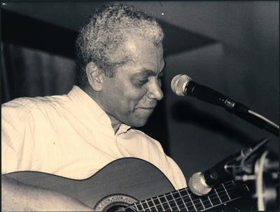 Paulinho da Viola ao microfone com o violão