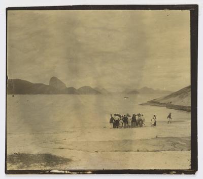 Grupo de pessoas na praia de Copacabana, no atual posto 6; ao fundo, o Morro do Pão de Açúcar
