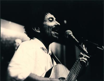 Tom Zé ao microfone com o violão