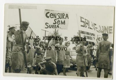 Calouros com roupa de estopa desfilam pela avenida W3 segurando cartazes como parte do trote da Universidade de Brasília