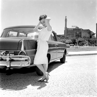 Modelo posa para foto ao lado de carro