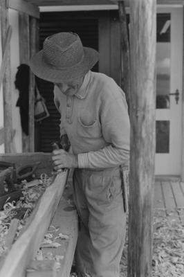 Homem aplainando madeira
