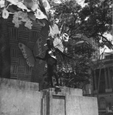 Carnaval de rua, pessoa fantasiada; ao fundo a Câmara dos Vereadores