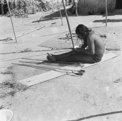 Homem do povo Karajá confeccionando flechas