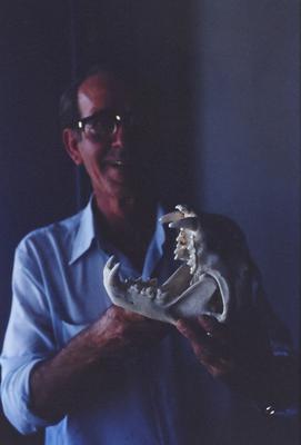 Homem não identificado com crânio de animal nas mãos