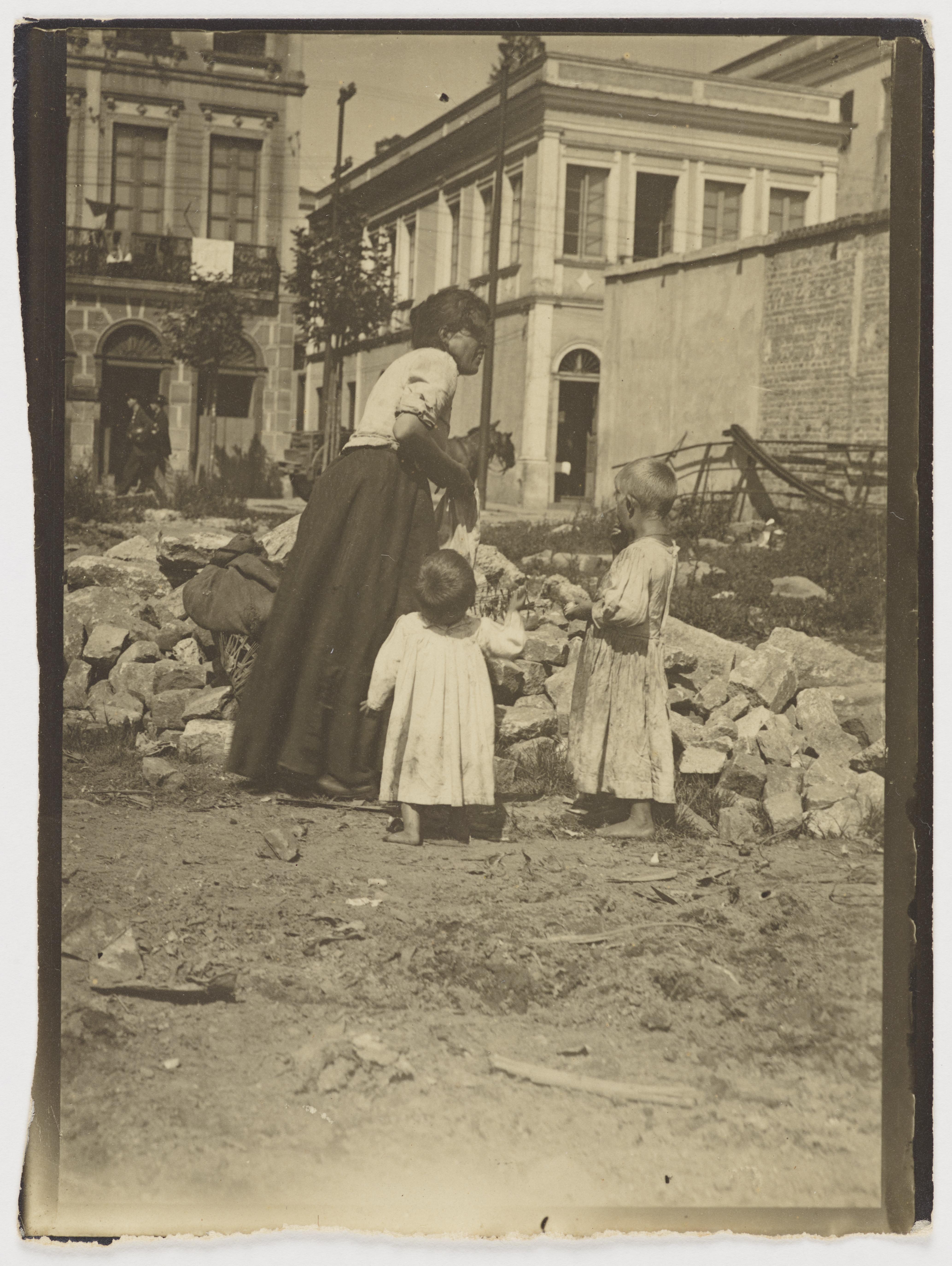 Mulher com crianças em terreno baldio