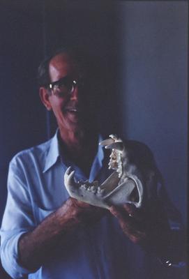 Homem não identificado com crânio de animal nas mãos