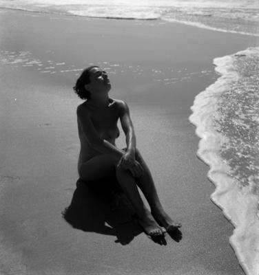 Mulher nua na beira do mar