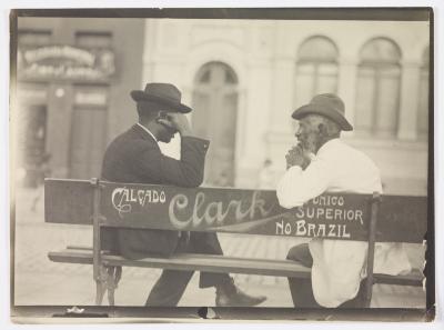 Homens conversando em banco de praça