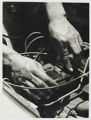 As mãos do mecânico sobre o motor