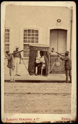 Escravizados transportando homem numa liteira