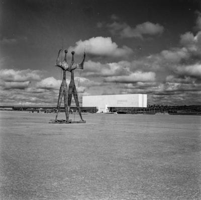 "Os Candangos" ou "Os Guerreiros", escultura de Bruno Giorgi. Ao fundo, o Museu Histórico de Brasília